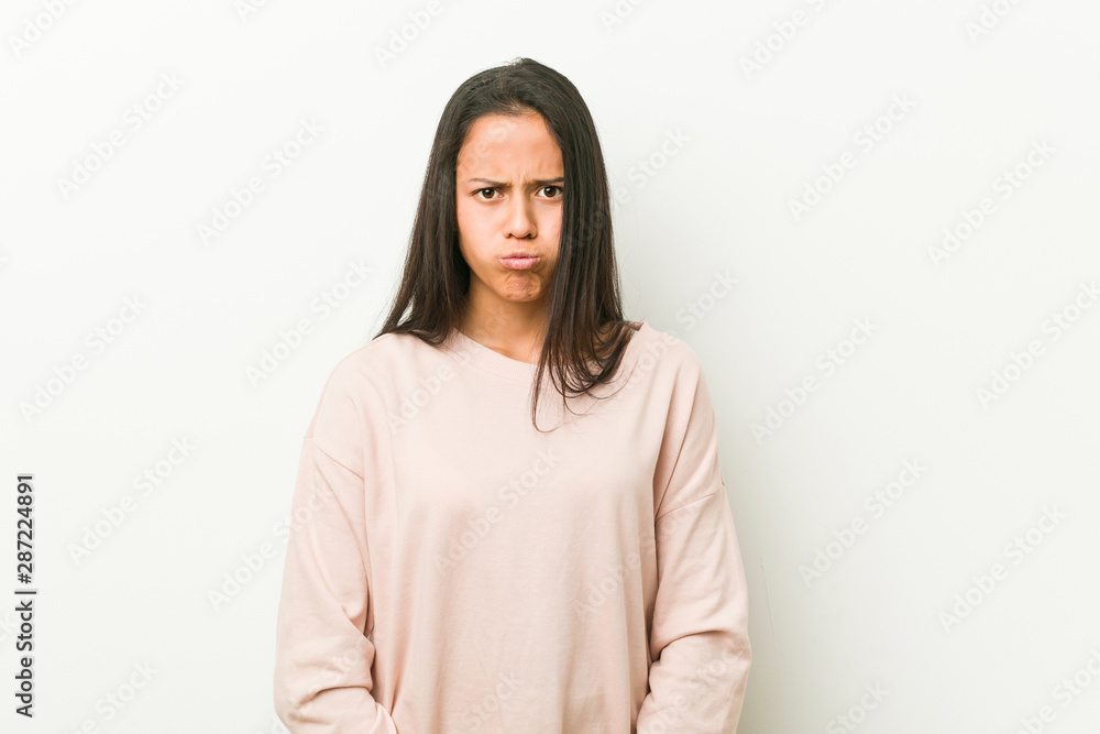 Young cute hispanic teenager woman blows cheeks, has tired expression. Facial expression concept. Young cute hispanic teenager woman blows cheeks, has tired expression. Facial expression concept.