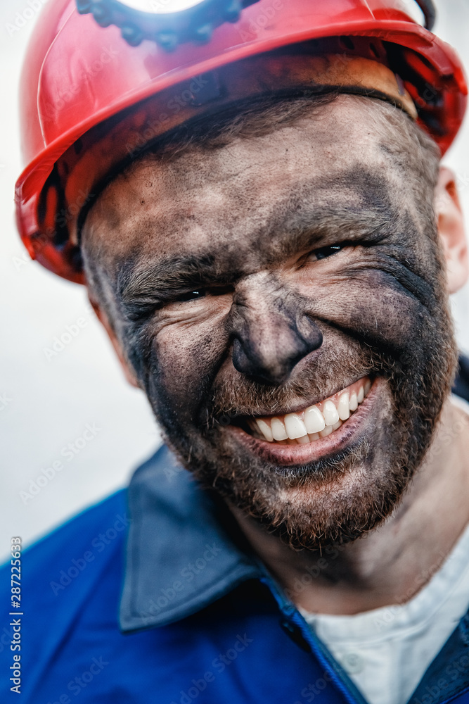 Portrait happy man miner after working in coal mine, dirty face in helmet. Concept vocation industrial worker Portrait happy man miner after working in coal mine, dirty face in helmet. Concept vocation industrial worker