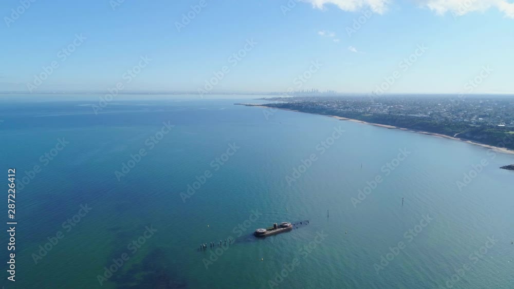 Forward flight along Melbourne coastline over historic shipwreck on bright sunny day Forward flight along Melbourne coastline over historic shipwreck on bright sunny day