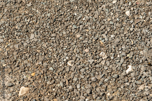 Trampled fine gravel on a walkway near the riverbank. Background.