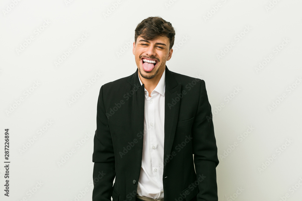 Young business hispanic man funny and friendly sticking out tongue. Young business hispanic man funny and friendly sticking out tongue.