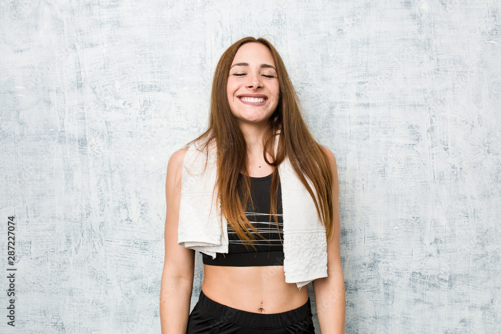 Naklejka premium Young fitness woman laughs and closes eyes, feels relaxed and happy.