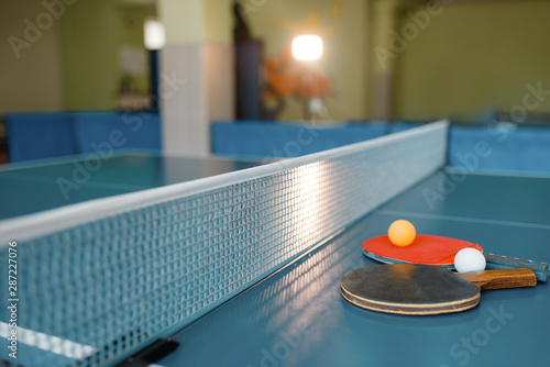 Ping pong rackets and balls on game table with net