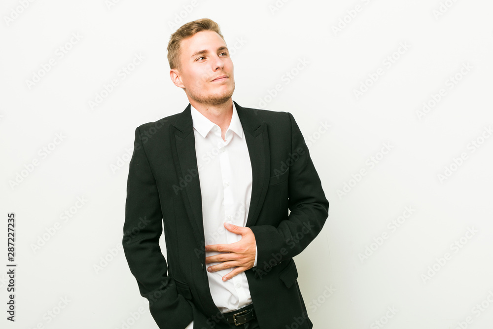 Young caucasian business man touches tummy, smiles gently, eating and satisfaction concept. Young caucasian business man touches tummy, smiles gently, eating and satisfaction concept.