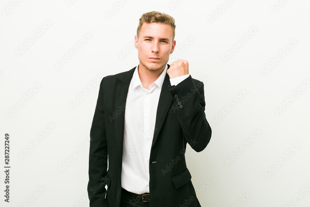 Young caucasian business man showing fist to camera, aggressive facial expression. Young caucasian business man showing fist to camera, aggressive facial expression.