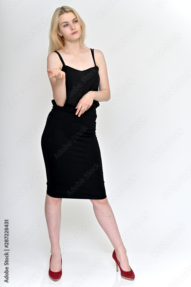 Full-length vertical portrait of a cute blonde student girl, a young woman in a black dress with beautiful curly hair on a white background in different poses. Beauty, brightness, emotions. Full-length vertical portrait of a cute blonde student girl, a young woman in a black dress with beautiful curly hair on a white background in different poses. Beauty, brightness, emotions.