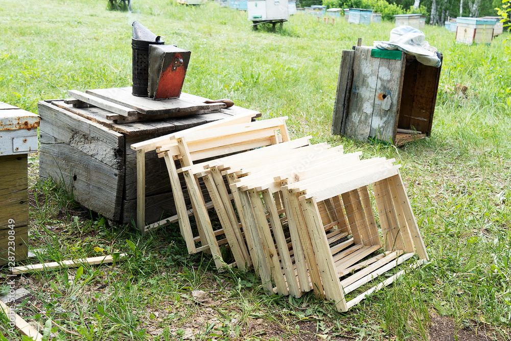 New wooden frames for bees. Frames without honeycombs and honey, stand in a row. Smoke for tool.