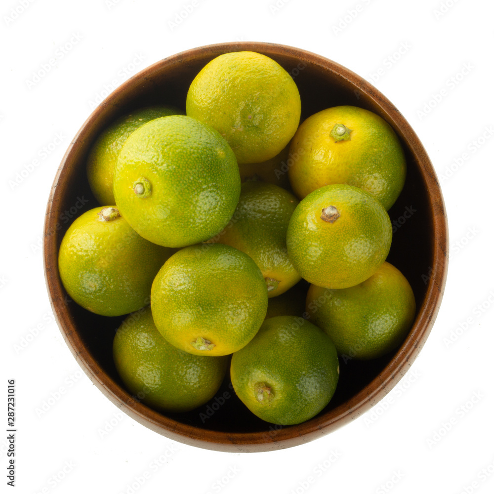 fresh limequat in wooden plate isolated on white background fresh limequat in wooden plate isolated on white background