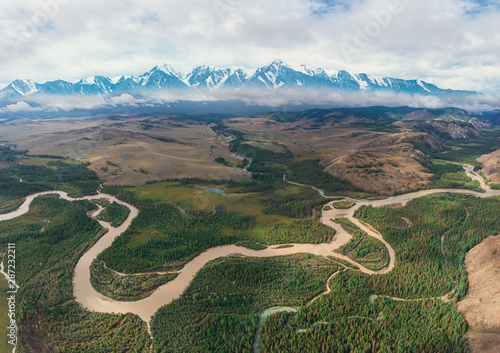 Kurai steppe and Chuya river on North-Chui ridge background. Altai mountains, Russia. Aerial drone panoramic picture. Giant ripples of the flow of water 15 thousand years ago