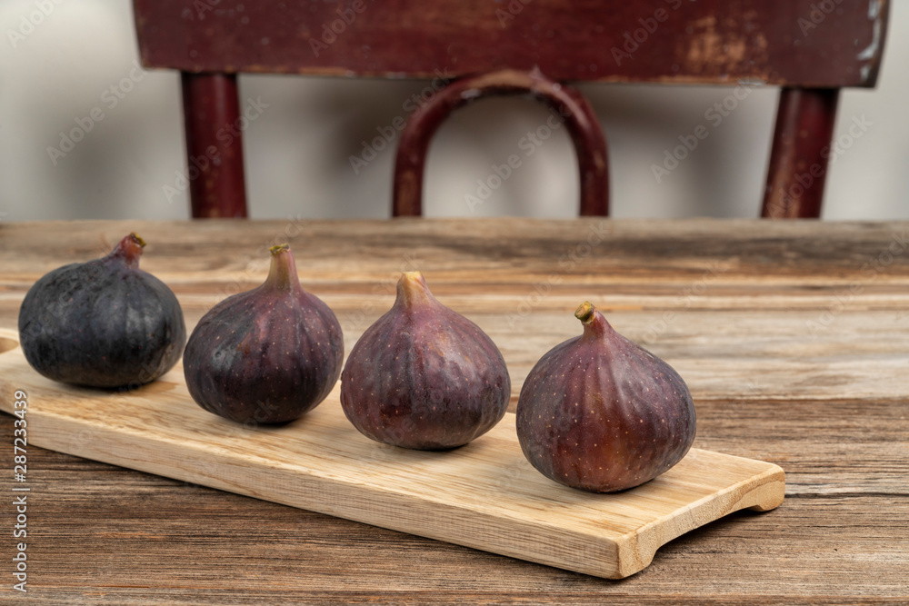 Fototapeta premium ripe purple figs on wooden table