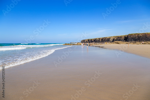 Ribadeo, Spain. Tourists on the picturesque Holy Water Beach (Praia de Augas Santas) photo