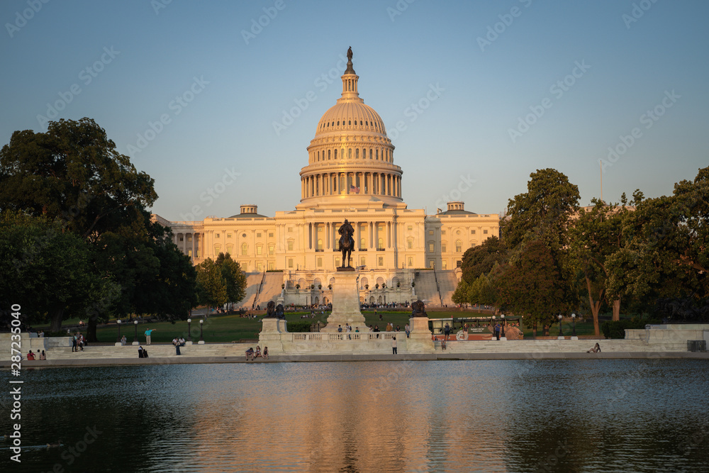 Obraz premium United States Capitol building at dusk sunset during a summer day, glowing from sunshine, with reflecting pond