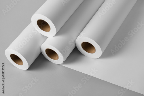 Blank white paper rolls isolated on gray background. Mockup paper for magazines, catalogs or newspapers isolated on gray backdrop, Printing house theme or wrapping paper for presents photo