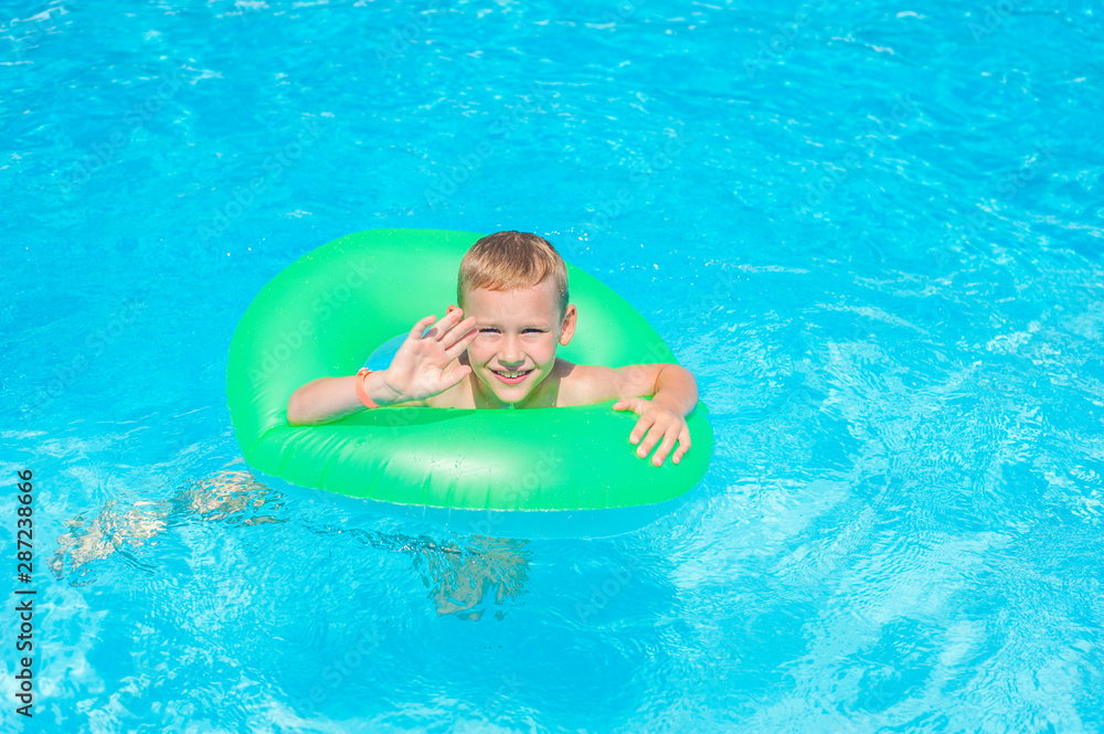 Cute kid swimming in a pool with clear water