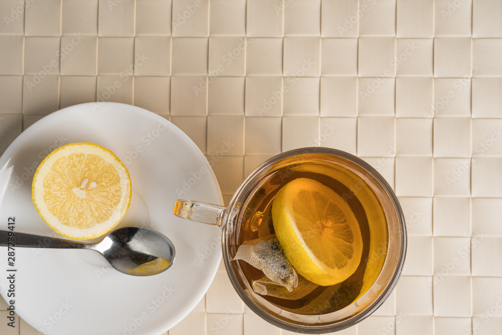 Black tea with lemon as a natural remedy for flu or cold. Autumn or fall season disease or illness. Top view. Copy space in the top right corner. Black tea with lemon as a natural remedy for flu or cold. Autumn or fall season disease or illness. Top view. Copy space in the top right corner.