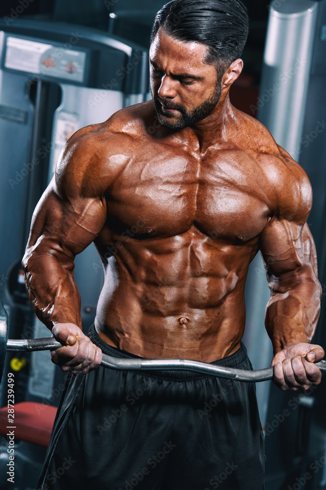 BodyBuilder Doing Barbell Bicep Curls at the Gym