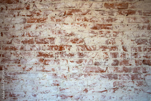 Weathered stained red brick wall background texture peeling plaster