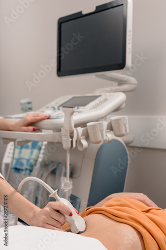 Female doctor doing examination for her patient using ultrasound scanner