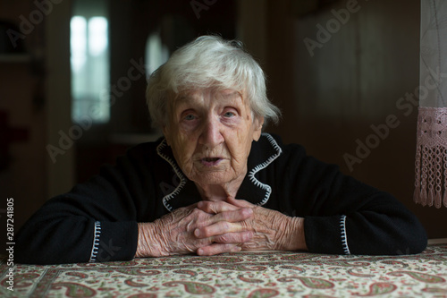 Portrait of a lonely sceptical old lady in his home.