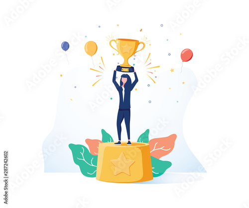 Beautiful smiling businesswoman is standing on a winners pedestal with a golden cup and confetti around.