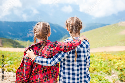 Beautiful happy little girls in mountains in the background of fog