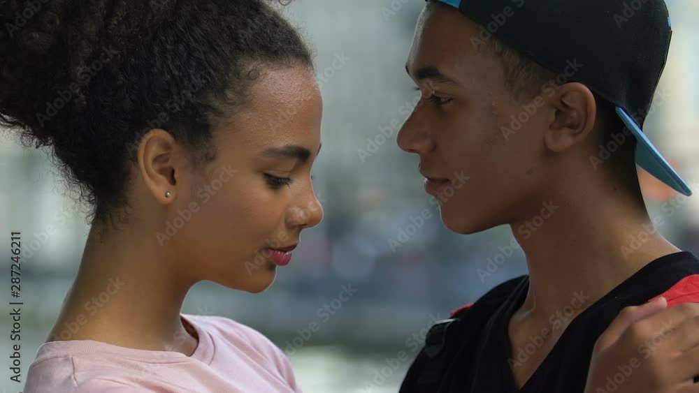 Serious mixed-race guy embracing nice girlfriend on romantic date, love and care Serious mixed-race guy embracing nice girlfriend on romantic date, love and care