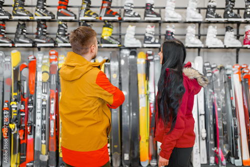 Couple choosing skiing or snowboarding equipment photo