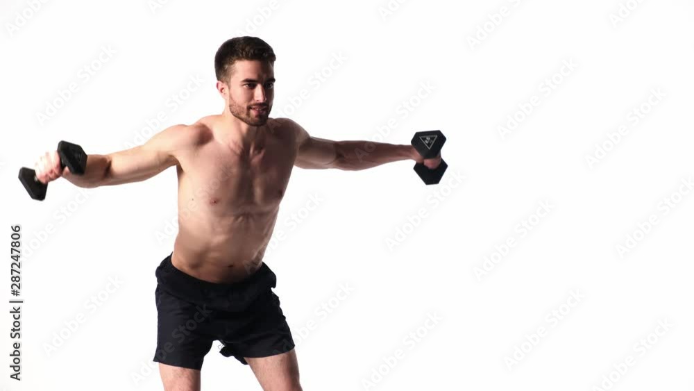 young handsome man with a beard naked torso on a white background is engaged in sports fitness activity lifting dumbbells. exercises with dumbbells on bissepsi and shoulders young handsome man with a beard naked torso on a white background is engaged in sports fitness activity lifting dumbbells. exercises with dumbbells on bissepsi and shoulders