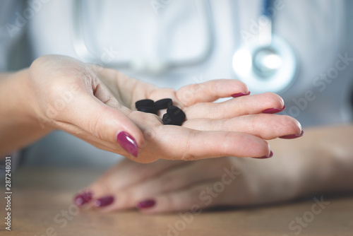 Doctor showing in hands activated charcoal.