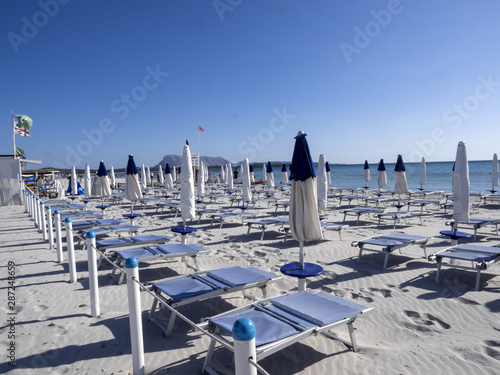 Fototapeta Naklejka Na Ścianę i Meble -  Morning empty beach with parasols, Sardinia, Italy