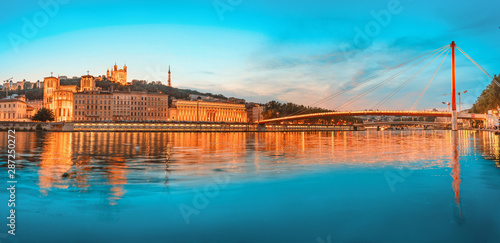 Tableau sur toile Lyon night cityscape with illuminated Courthouse and red pedestrian bridge over Saone river