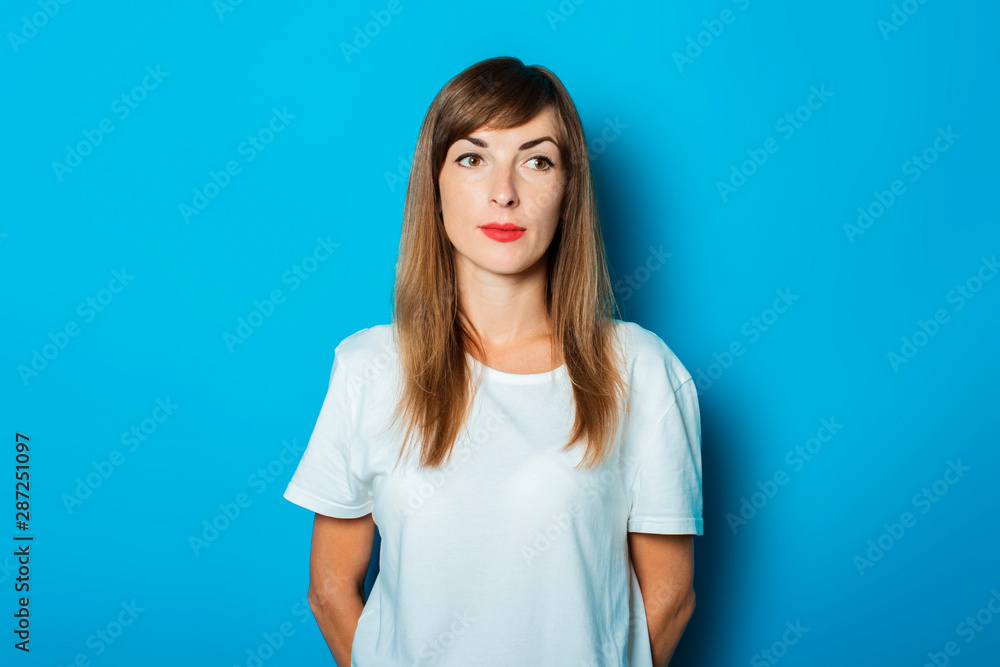 Young woman in white t-shirt on a blue background Young woman in white t-shirt on a blue background