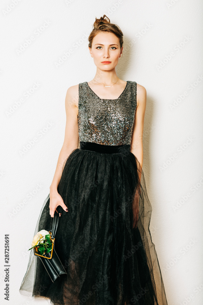 Fashion portrait of stylish young woman wearing long black dress Fashion portrait of stylish young woman wearing long black dress
