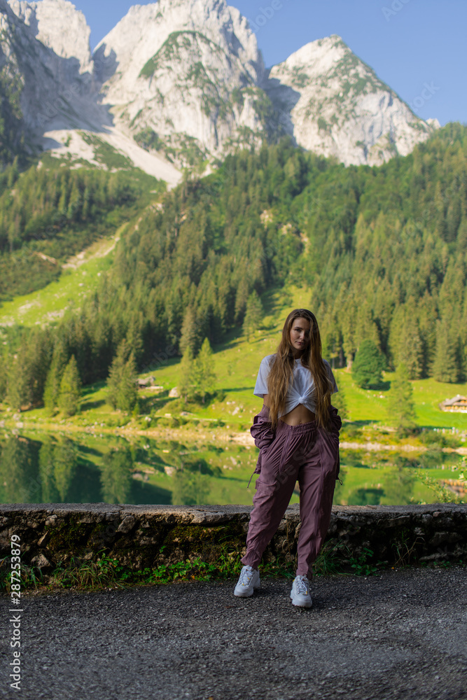 Naklejka premium Beautiful young sports girl on a background of a forest in the mountains