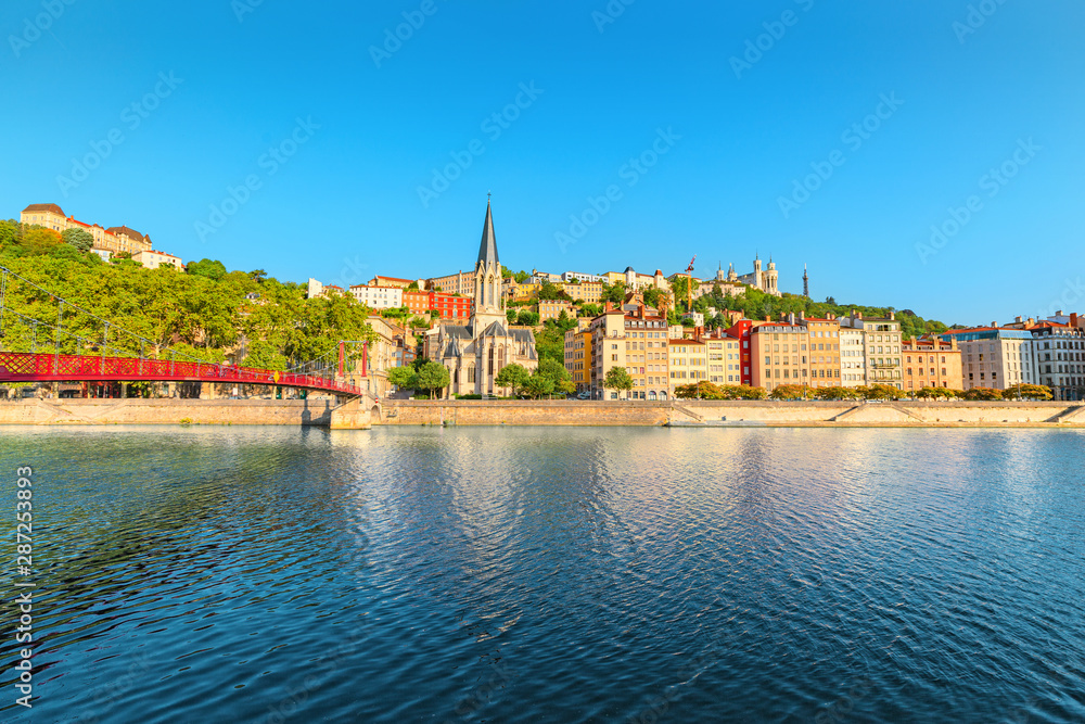 Early morning cityscape view of St Georges pedestrian bridge in Lyon city with old church on the opposite bank of the river. Travel destinations in France