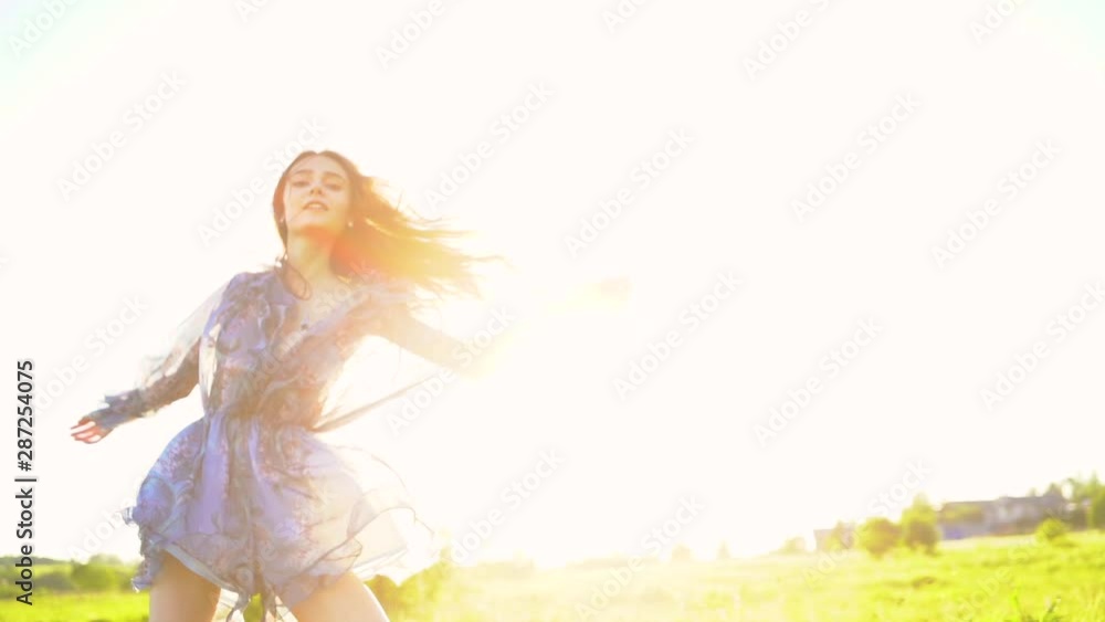 young beautiful girl with long hair walks in a summer field on sunset, girl model. Walk in nature and fresh air young beautiful girl with long hair walks in a summer field on sunset, girl model. Walk in nature and fresh air