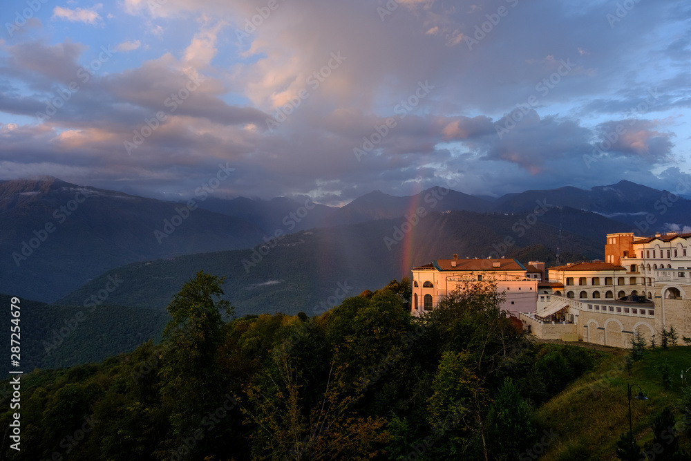 Resort at sunset in the mountains with a rainbow.