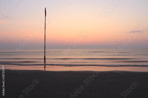 sunset on the sea with a pole