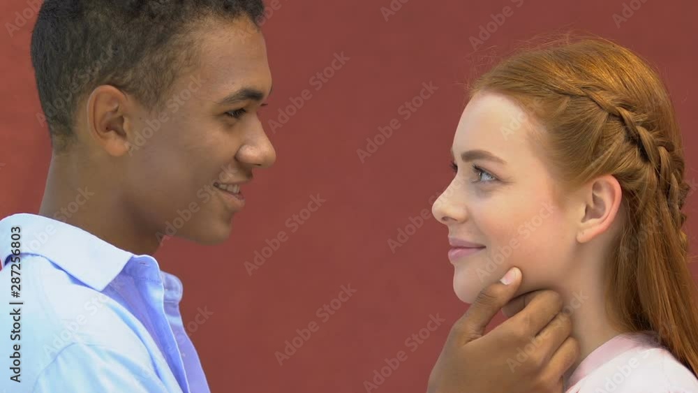 Happy afro-american male touching face of beautiful caucasian girlfriend, dating Happy afro-american male touching face of beautiful caucasian girlfriend, dating