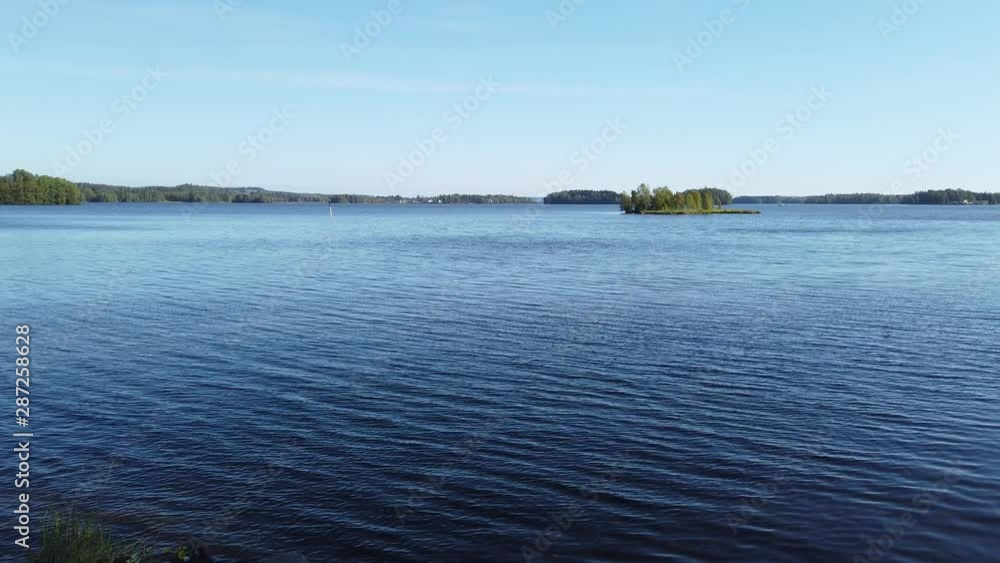 Tranquil lake view on summer day in Finland. Only small ripple on water surface. Tranquil lake view on summer day in Finland. Only small ripple on water surface.