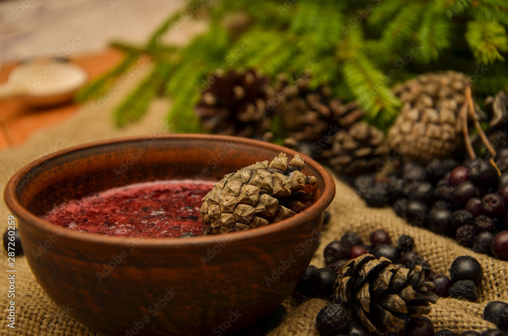 Jam of black Rowan, cones and branches of the Christmas tree on the background of burlap. Preparations for the winter. Gift of nature. Jam of black Rowan, cones and branches of the Christmas tree on the background of burlap. Preparations for the winter. Gift of nature.