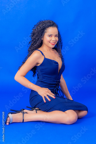 Curly hair girl wearing blue dress studio shot