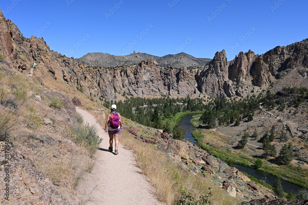 Young woman on Misery Ridge Trail in Smith Rock State Park near Terrebonne, Oregon on a coudless summer day.