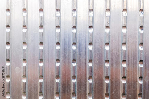 Metallic texture of an aluminum plate with slits for use as an industrial background.