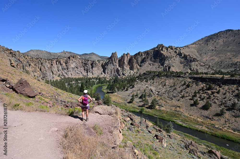 Young woman on Misery Ridge Trail in Smith Rock State Park near Terrebonne, Oregon on a coudless summer day. Young woman on Misery Ridge Trail in Smith Rock State Park near Terrebonne, Oregon on a coudless summer day.