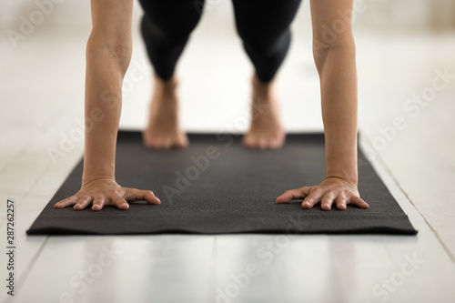 Young woman practicing yoga, Push ups or press ups, Plank © fizkes