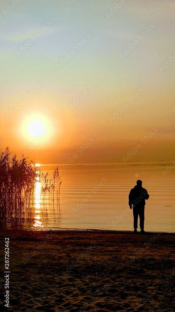 Fototapeta premium silhouette of man on the beach at sunset