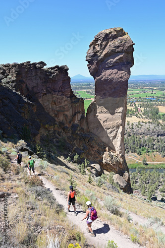 Hikers on Misery Ridge Trail in Smith Rock State Park near Terrebonne, Oregon on a cloudless summer day.