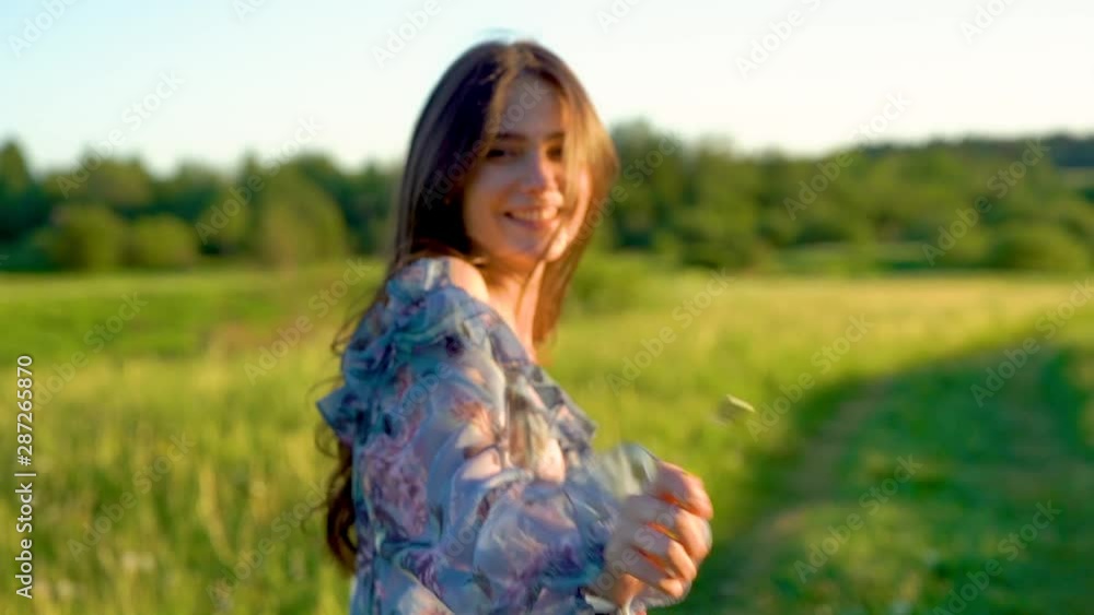 young beautiful girl with long hair walks in a summer field on sunset, girl model. Walk in nature and fresh air young beautiful girl with long hair walks in a summer field on sunset, girl model. Walk in nature and fresh air