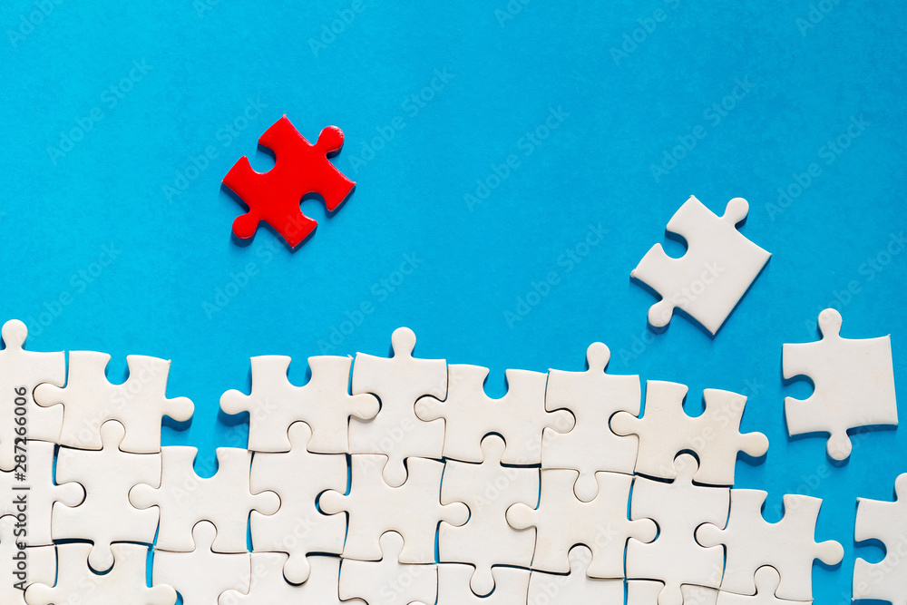 Unfinished red with white jigsaw puzzle pieces Unfinished red with white jigsaw puzzle pieces